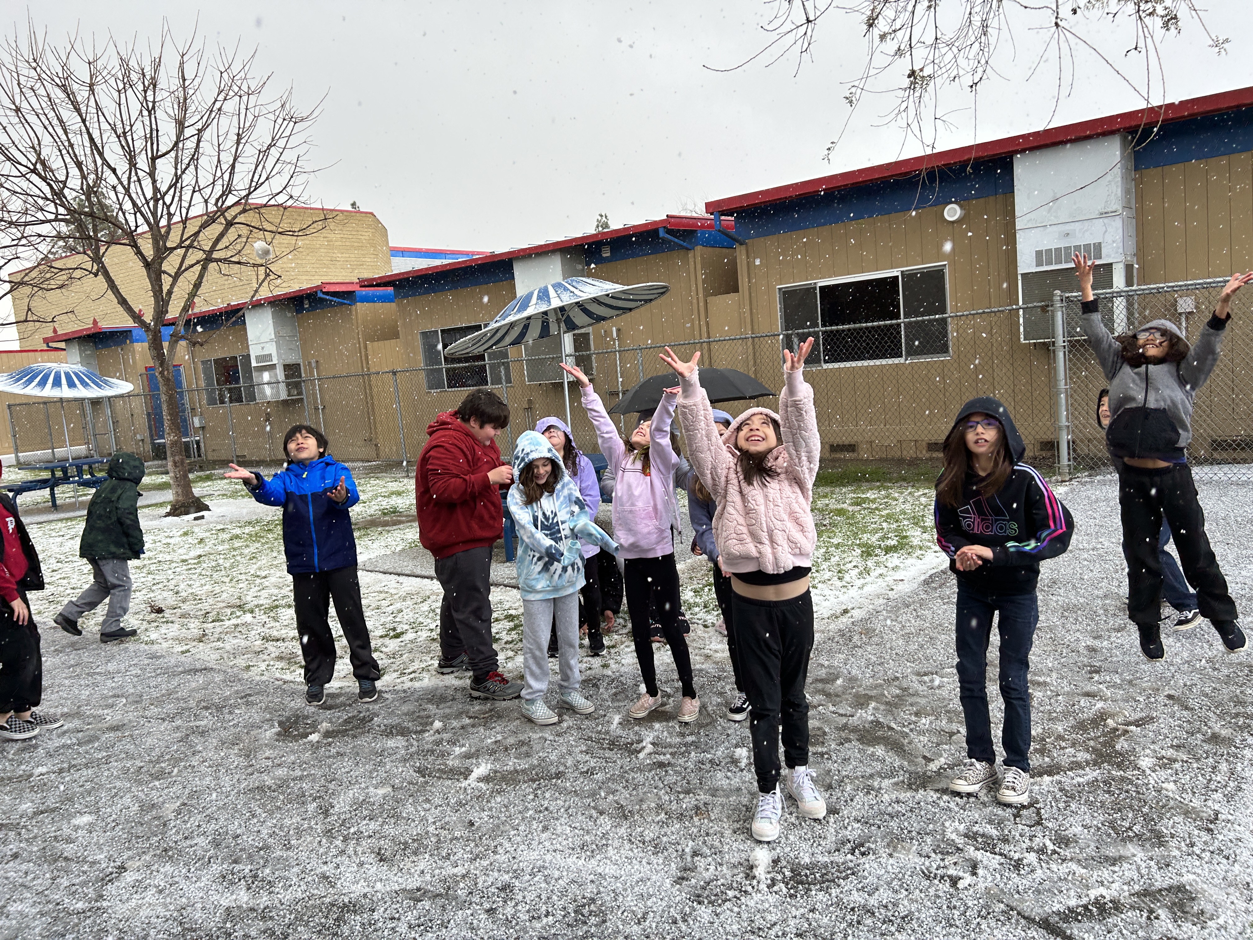 students playing in snow at school