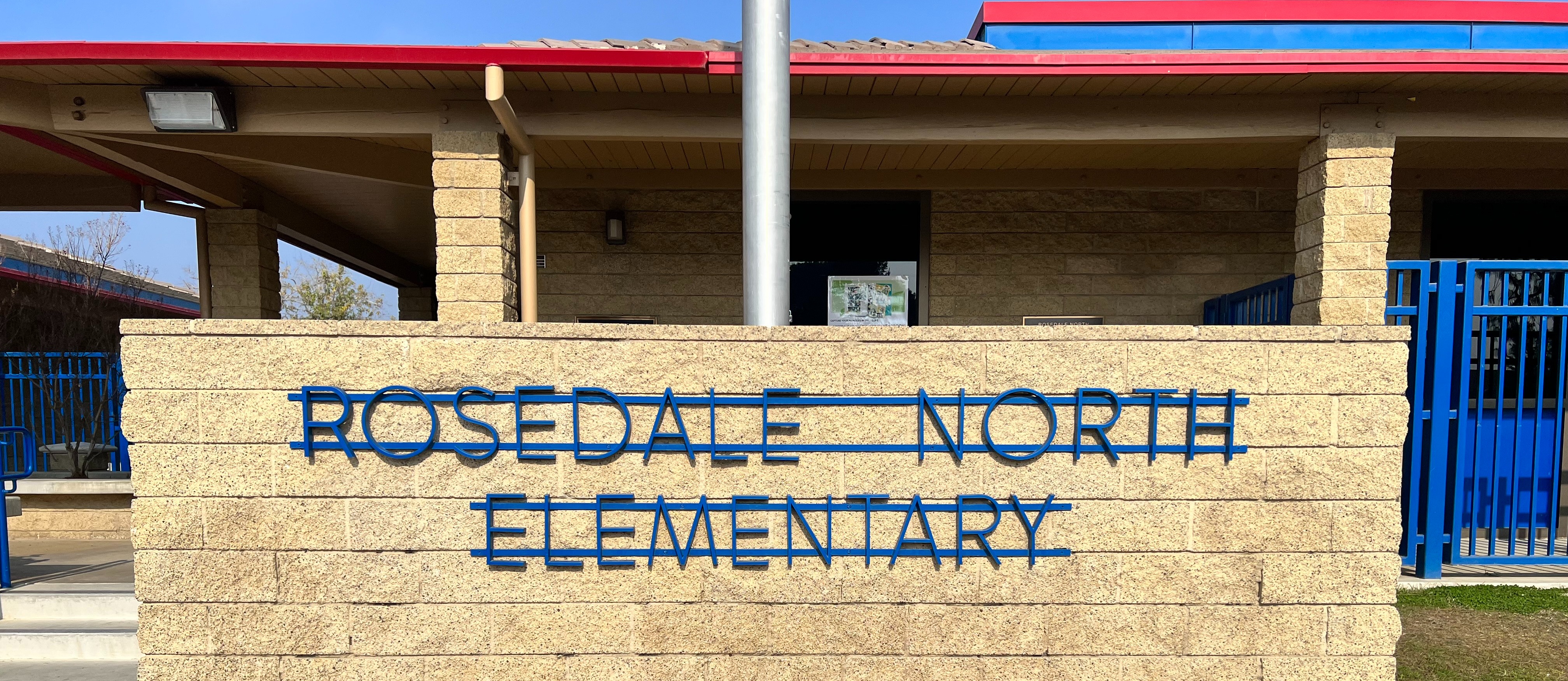 Rosedale North Elementary Sign in blue on brown brick wall