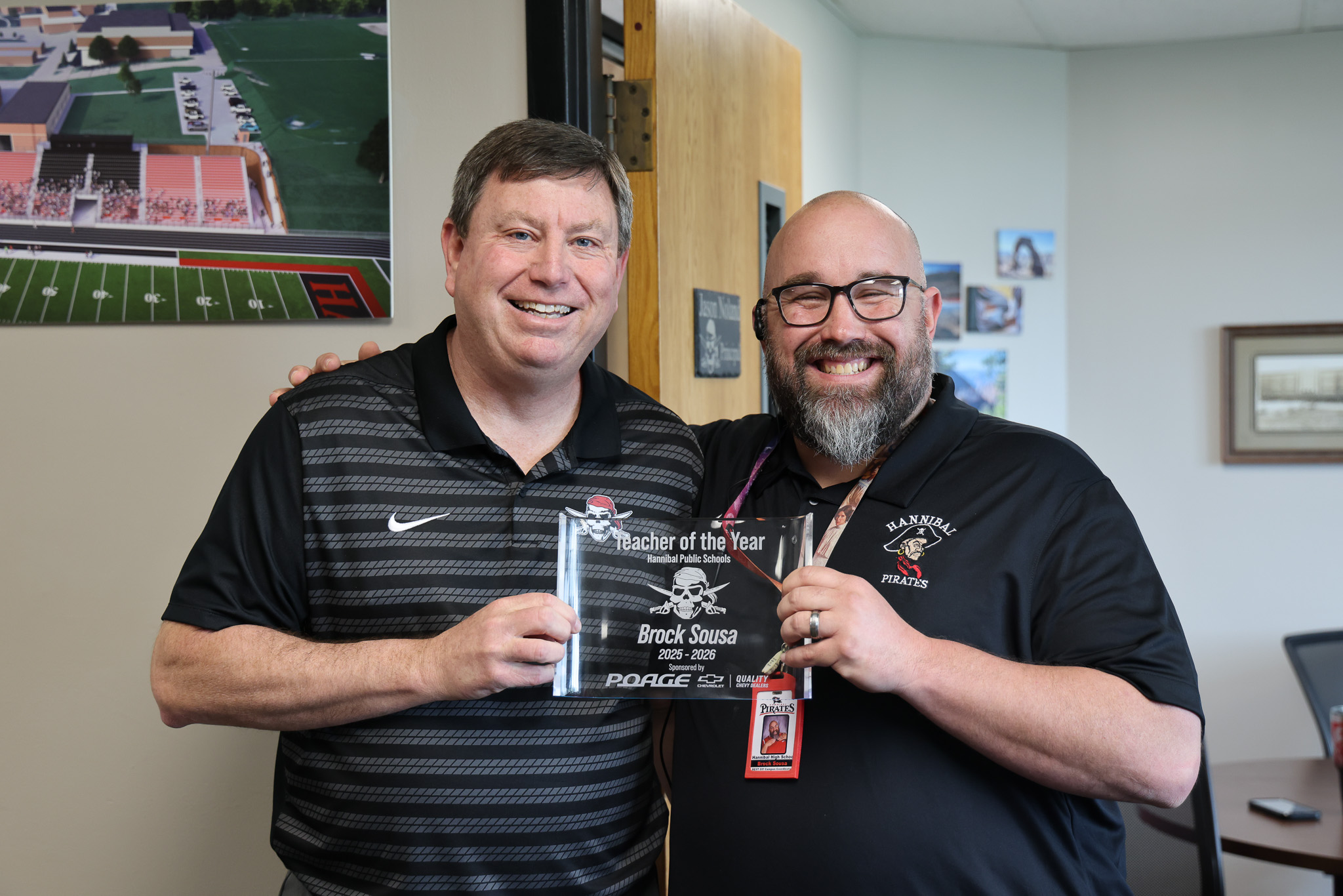 teacher holding teacher of the year plaque