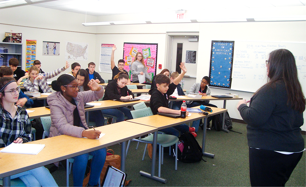 Students raising hand at classroom