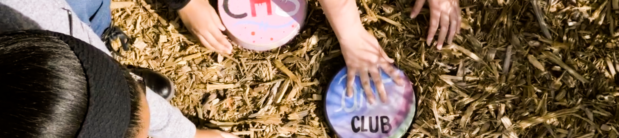 Kids holding painted plates in the ground