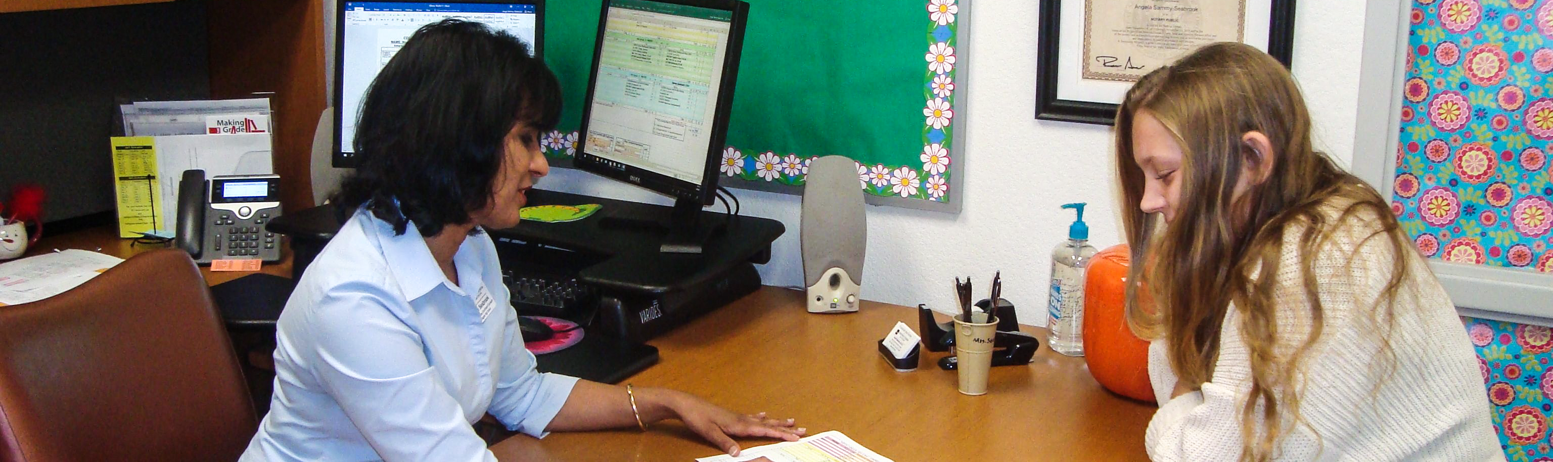 Counselor talking to a teen student at office