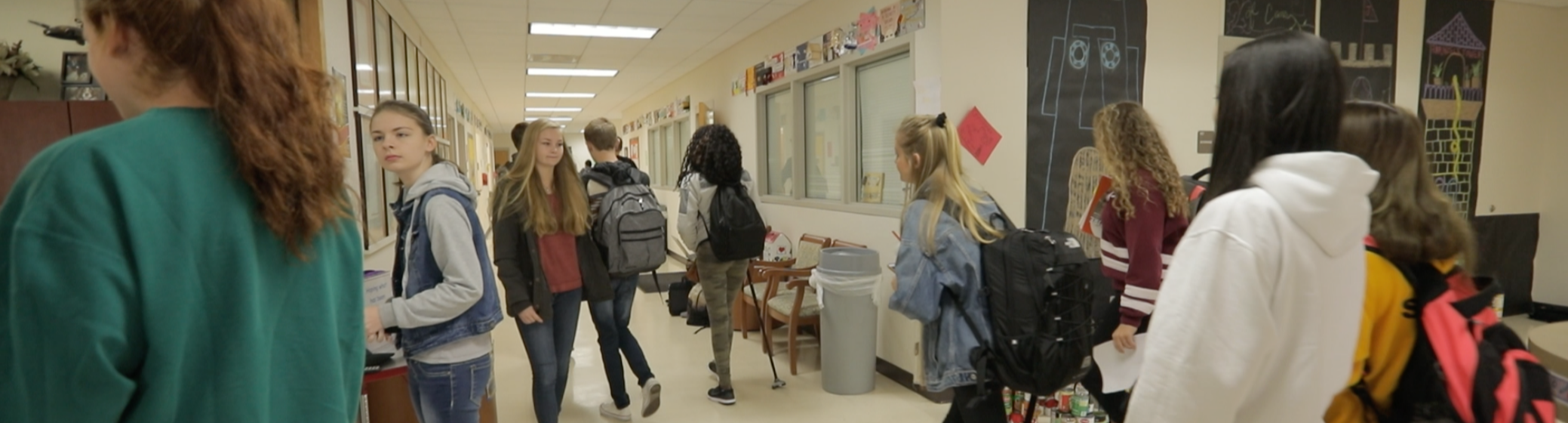 Group of teens walking at school hallway