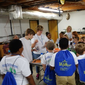 Teacher and kids at class wearing blue backpacks