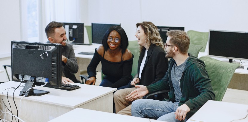 Group of young people laughing looking at a computer