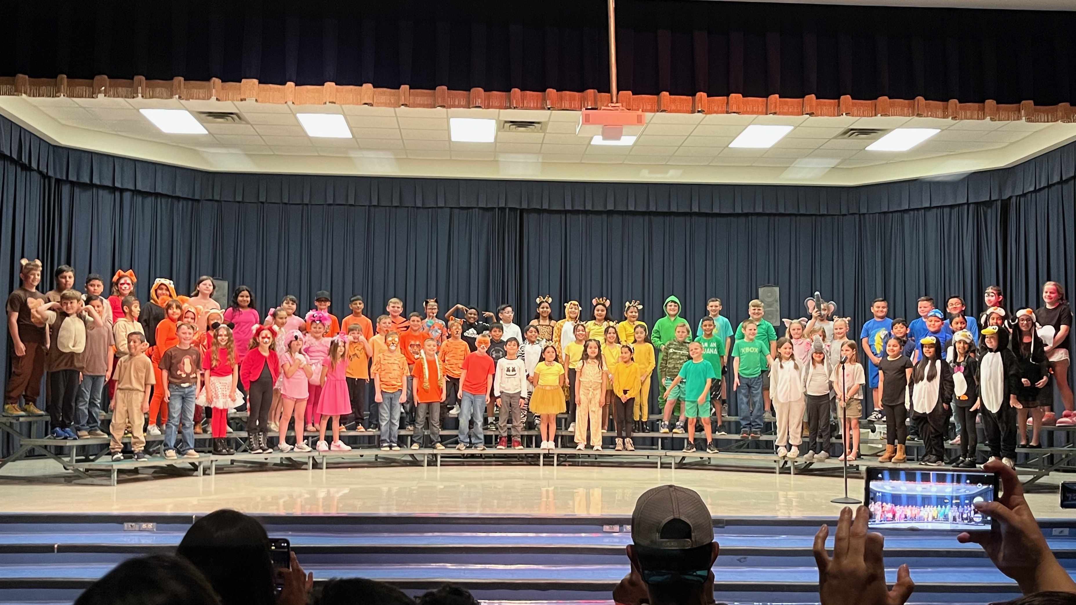 3rd grade students standing on stage ready to sing. 
