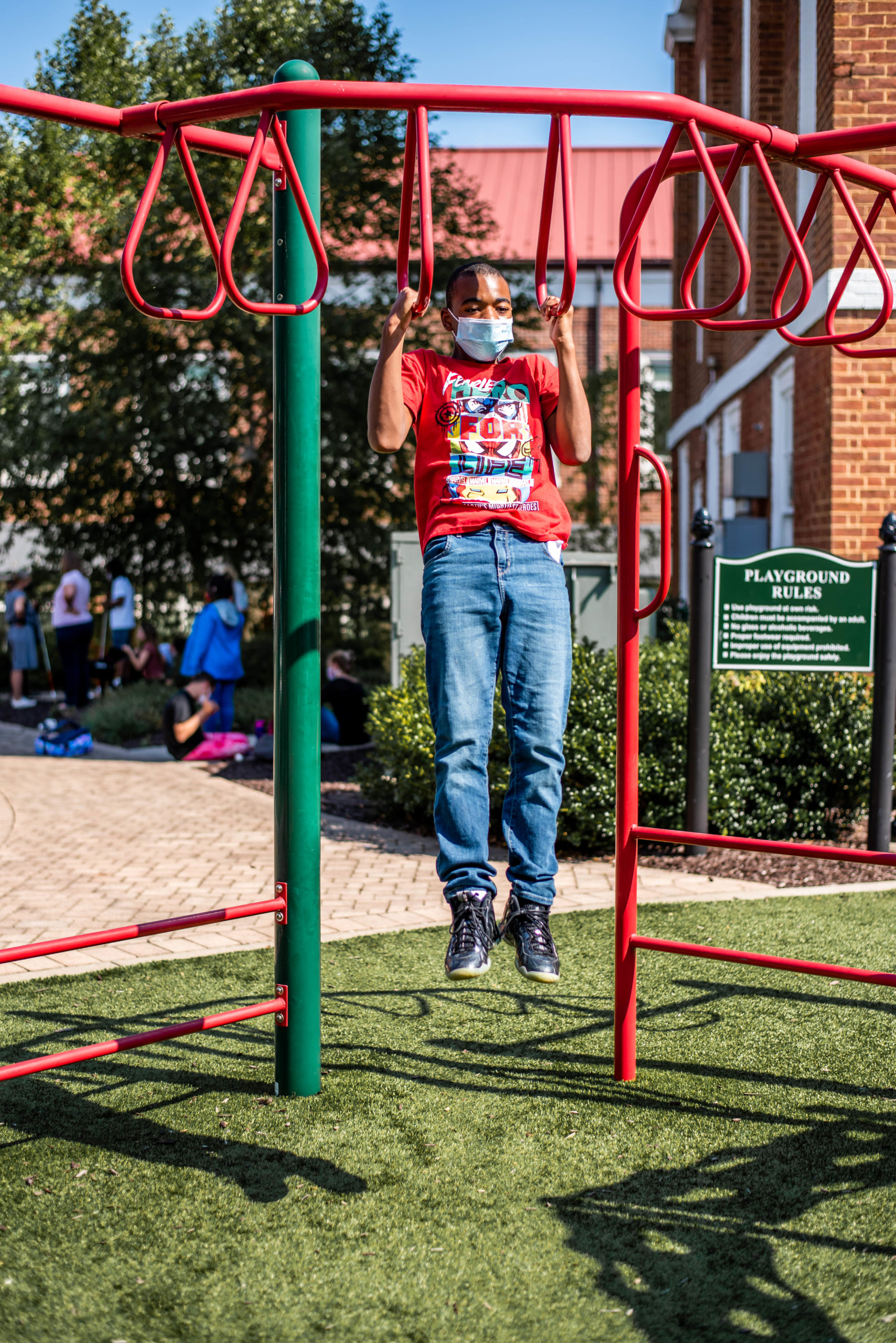 A student playing on playground equipment