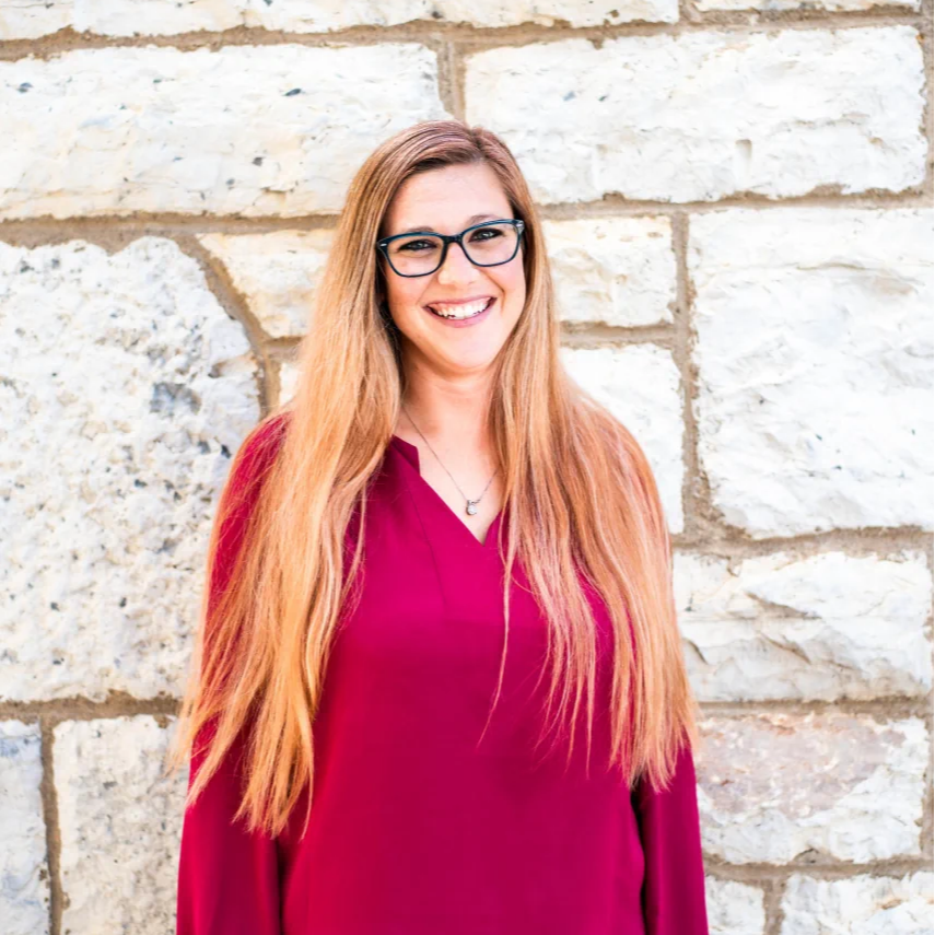 Julie Saum upper body picture against a white stone wall