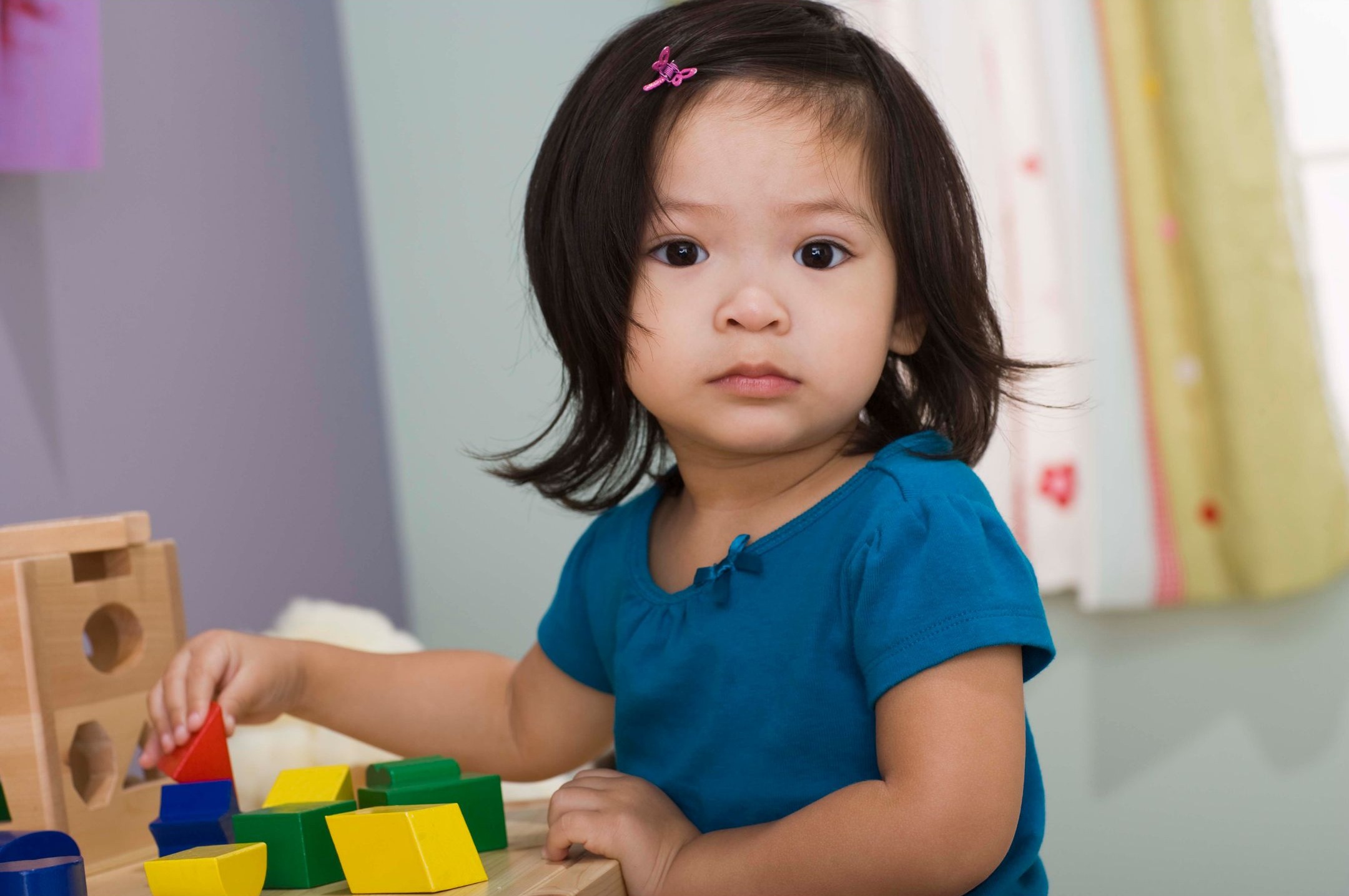 young girl playing with blocks at a table