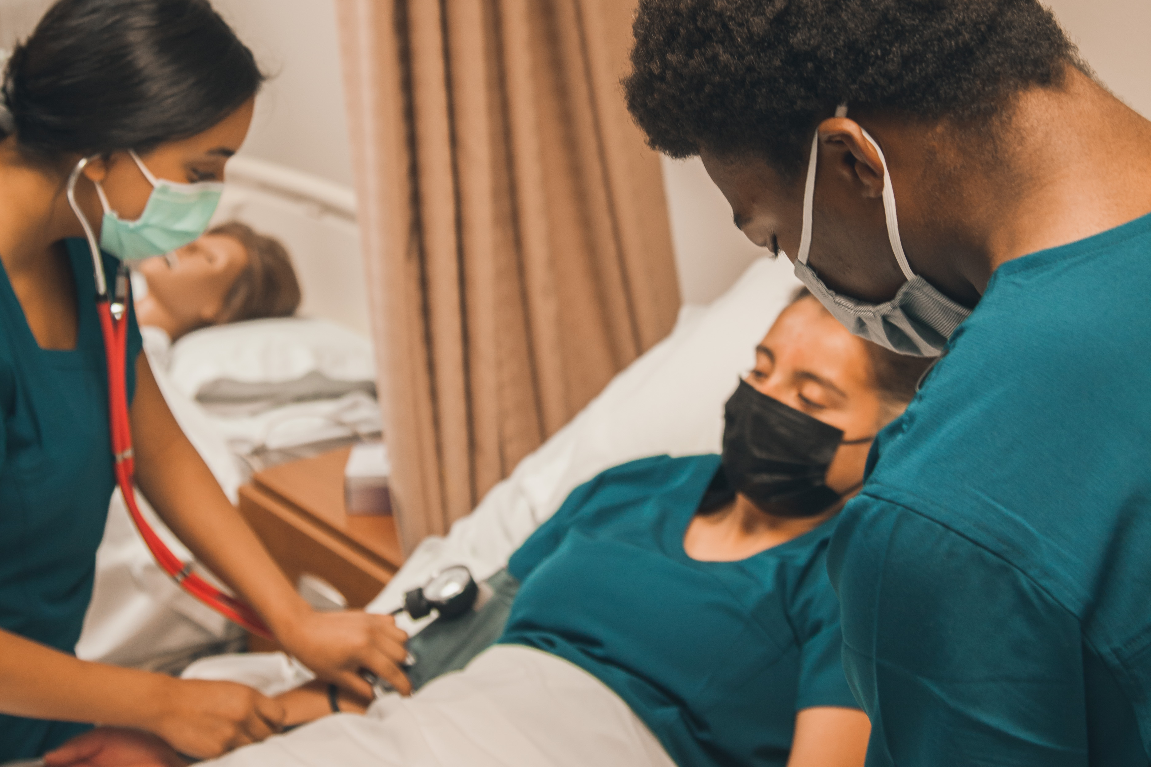 Students taking vitals of a patient