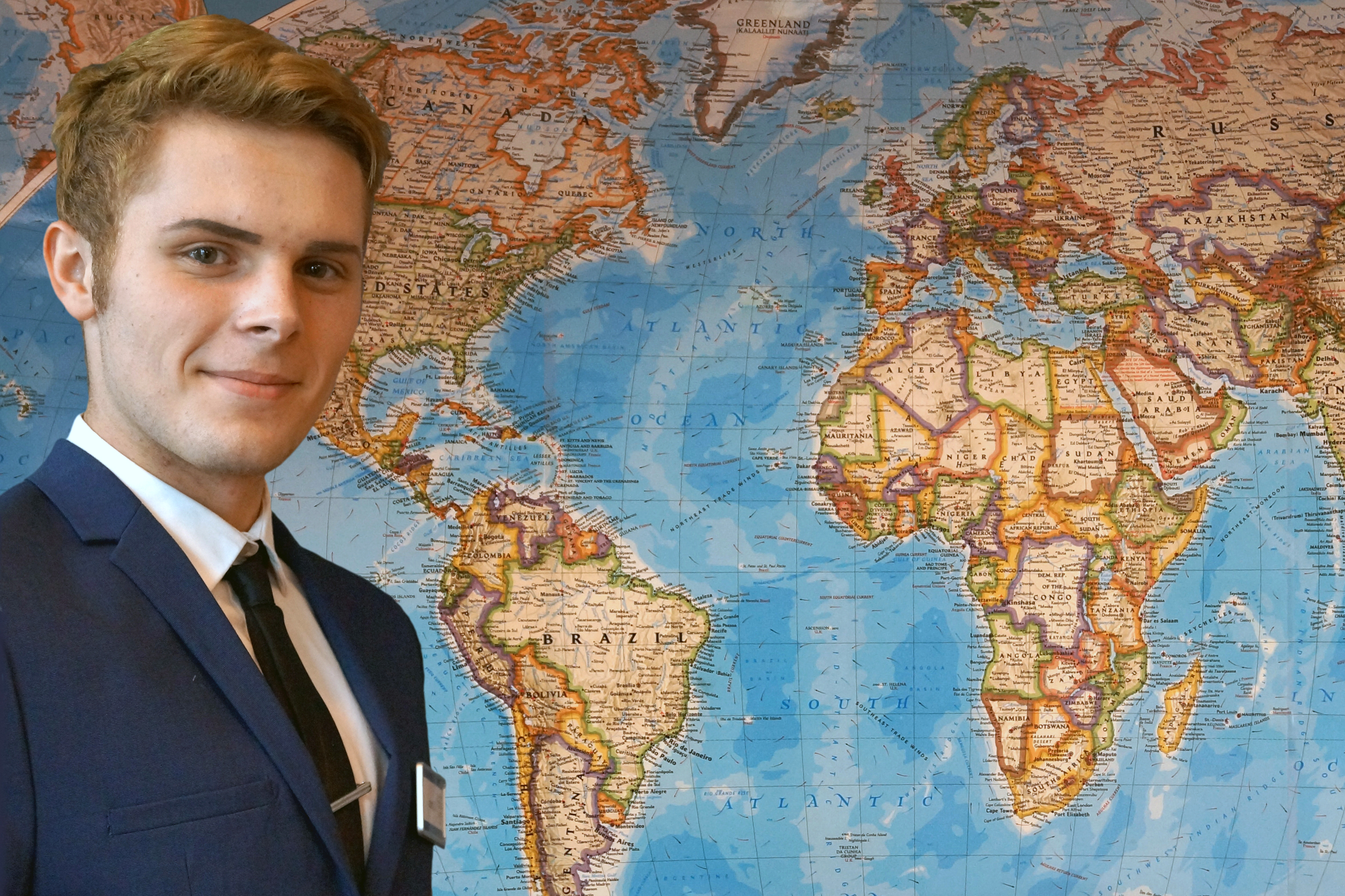 STUDENT IN UNIFORM IN FRONT OF WORLD MAP