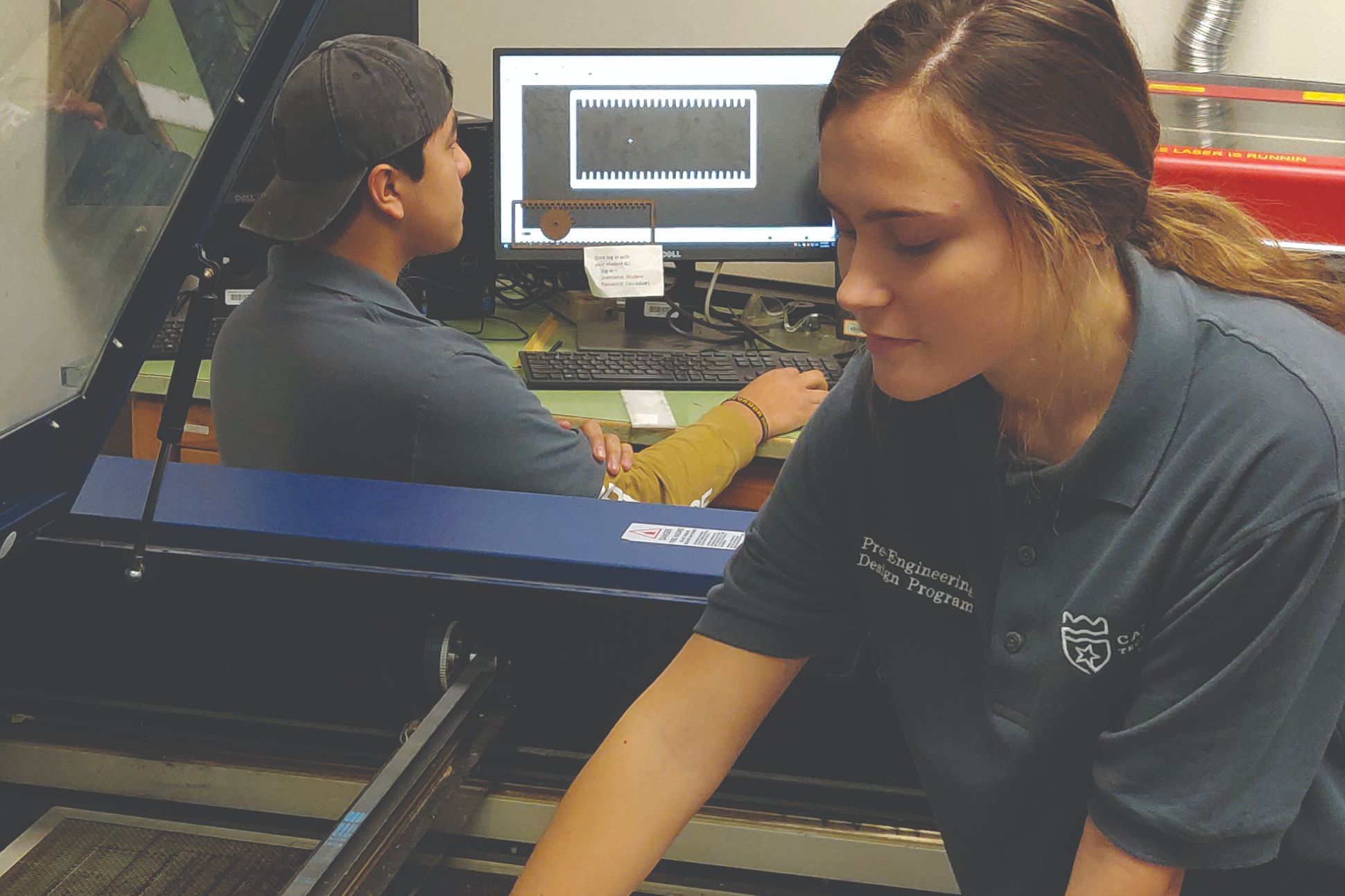 STUDENT WORKING ON A LASER CUTTER