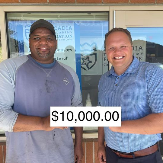 Reggie and Dave holding a $10,000 check
