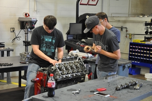 Automotive students working on an engine