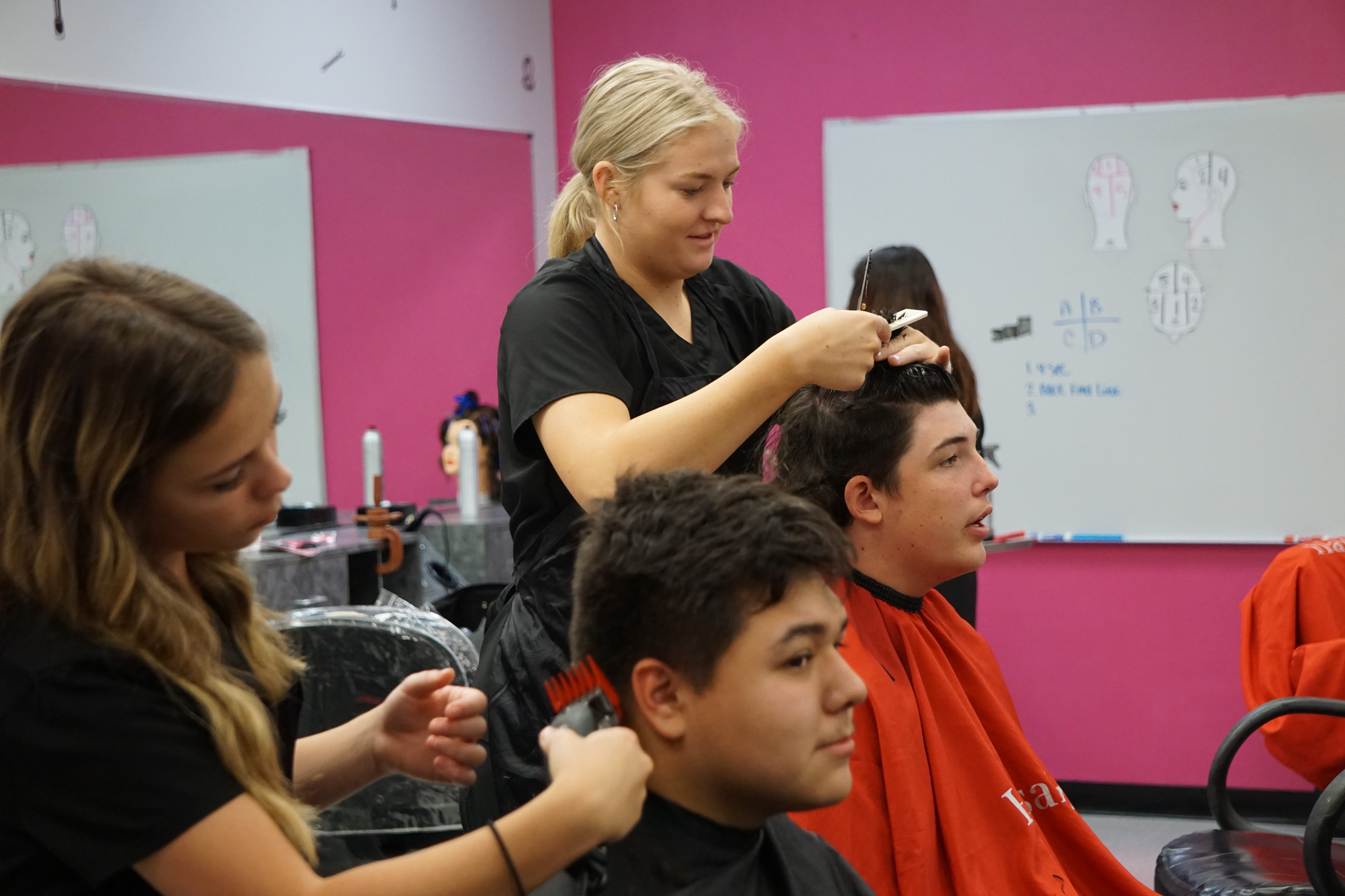 Cosmetology students cutting hair in the salon