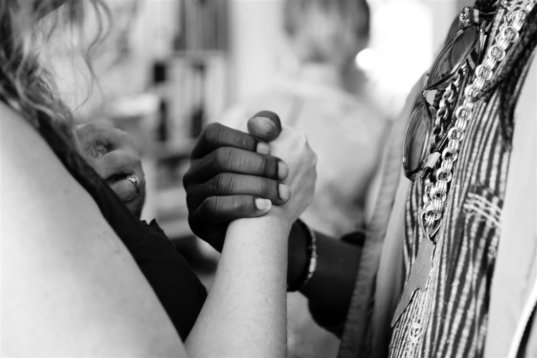 A black and white picture of two people joining hands