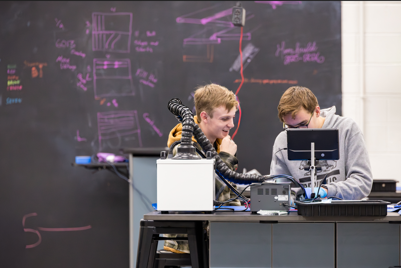 Two students working in front of a chalkboard in the CIC