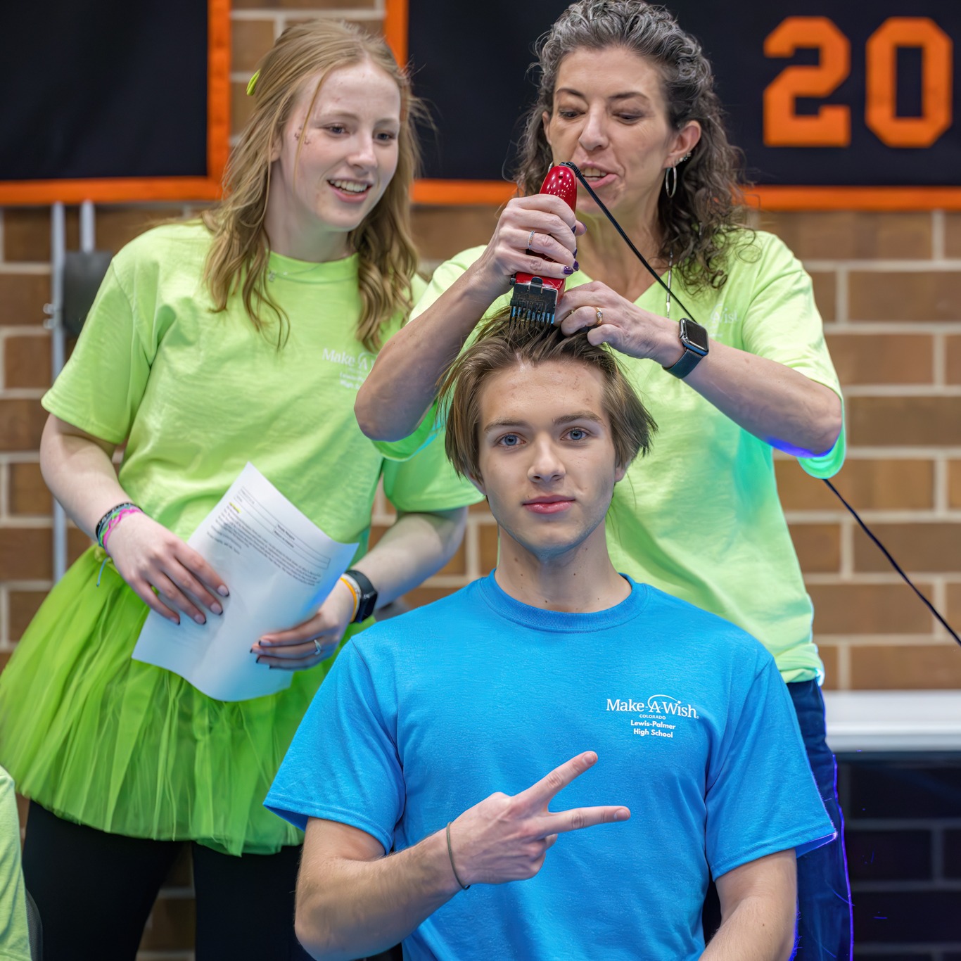 A male student getting his head shaved to raise money for Make-A-Wish Colorado