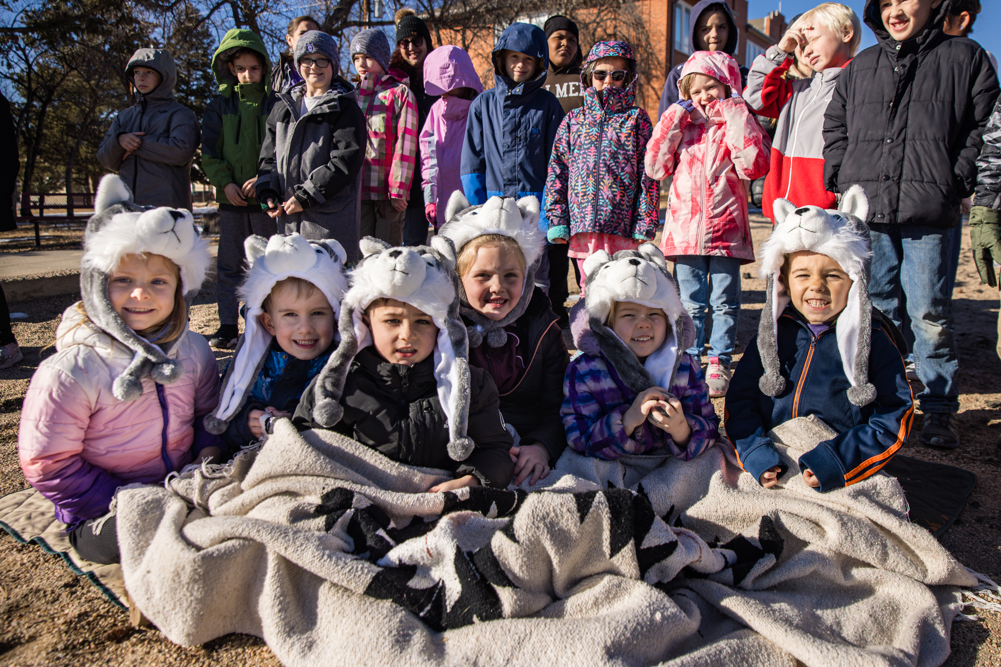 HSEA students sitting together while wearing husky hats