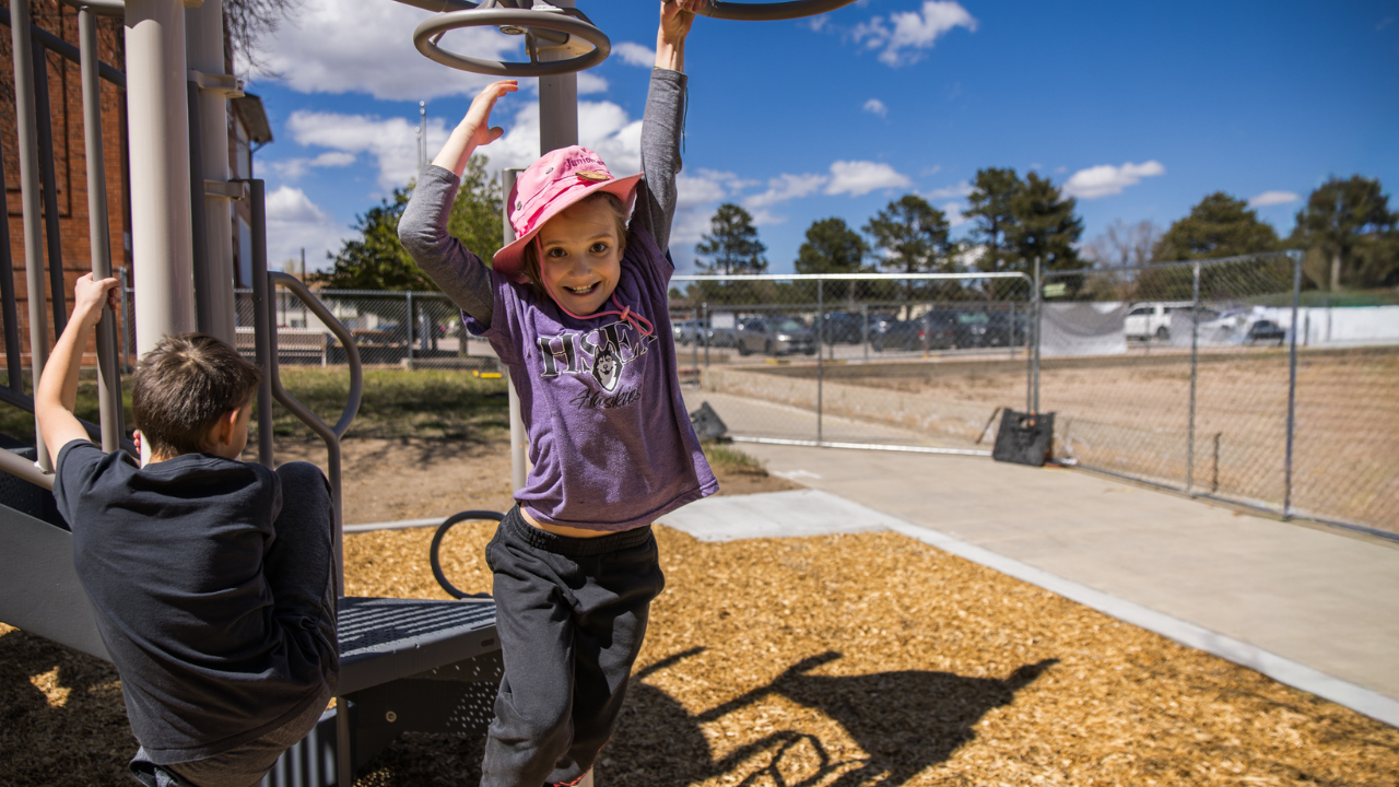 An HSEA student doing the monkey bars on the new playground