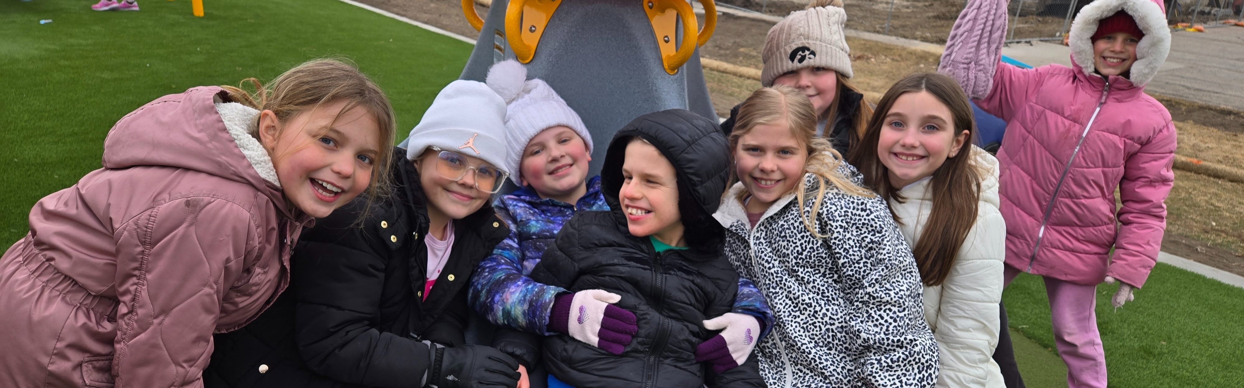 Group of west students playing together on the circular playground swing