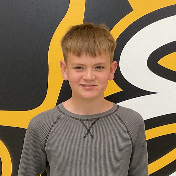 Calvin Wunderlich wearing brown shirt in front of the MP Hawk wall decal