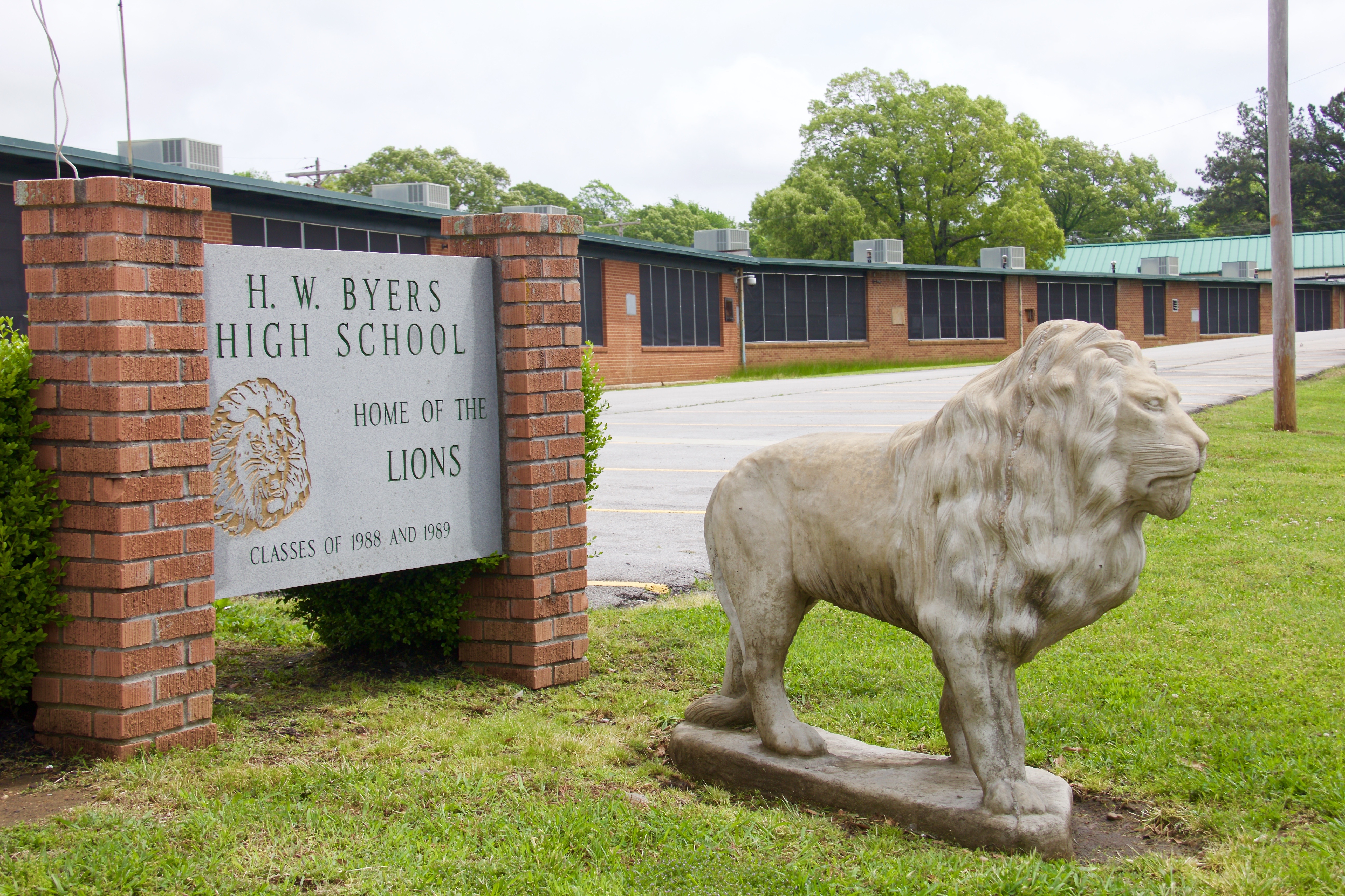 Sign out front of H.W. Byers with a statue of a lion