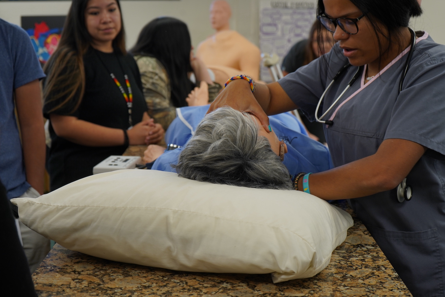 Students tending to a patient in bed