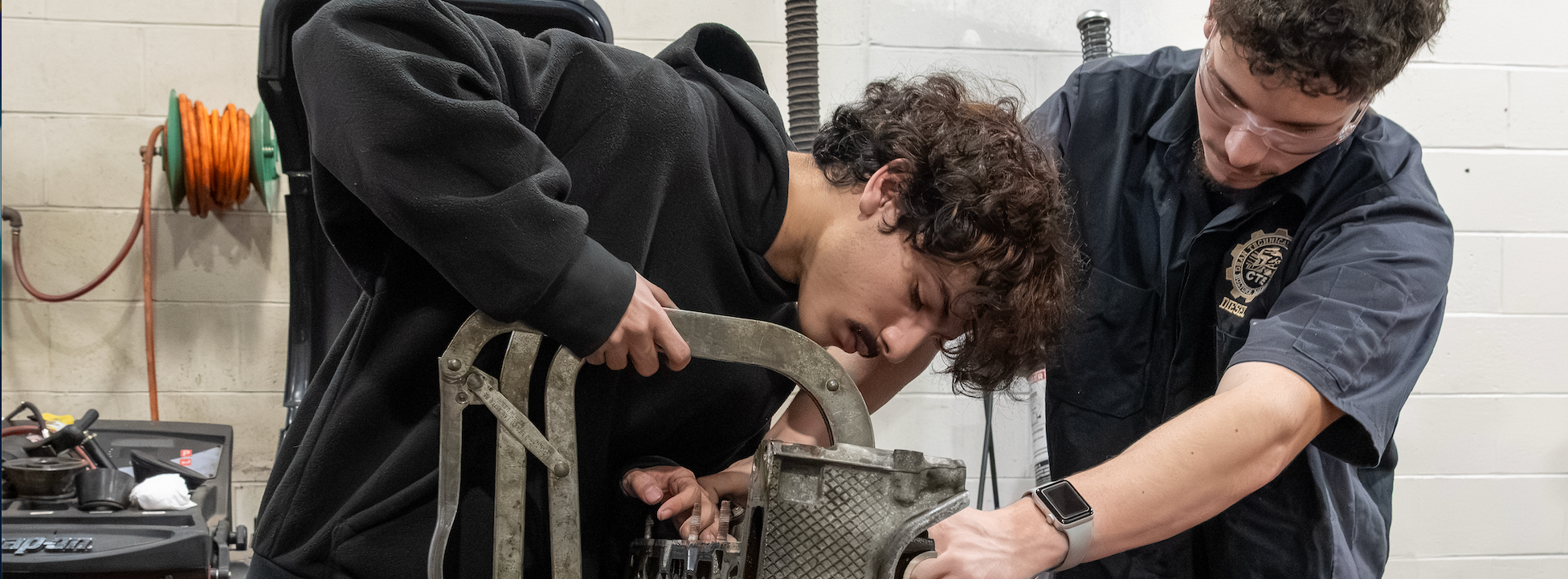 Two students work on an engine