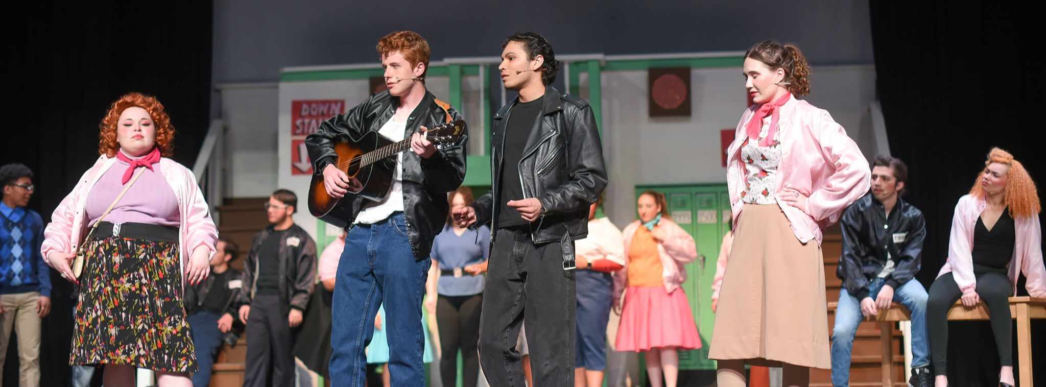students on auditorium stage performing in the high school musical 