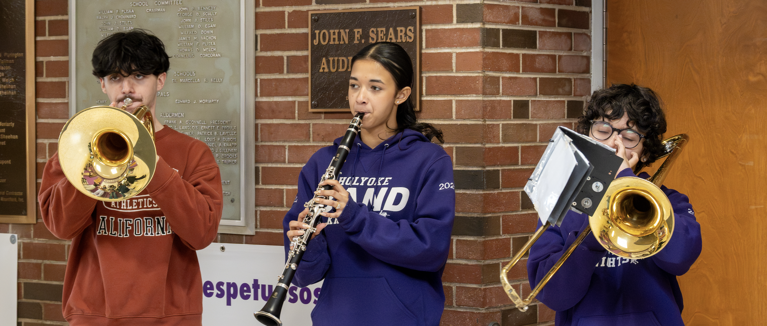 Students play band instruments in the hallway