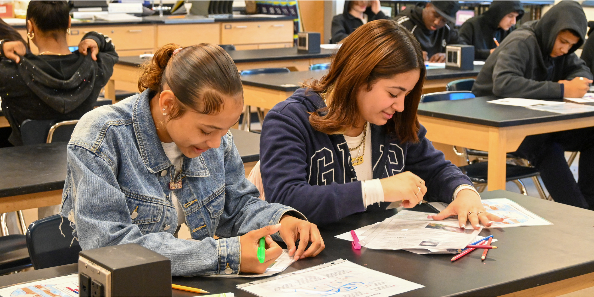 two students sitting at a table working on a classroom assignment