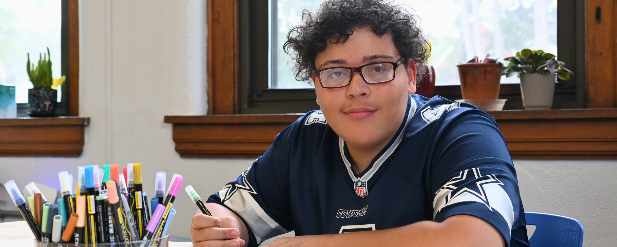 Student in art class smiles at the camera
