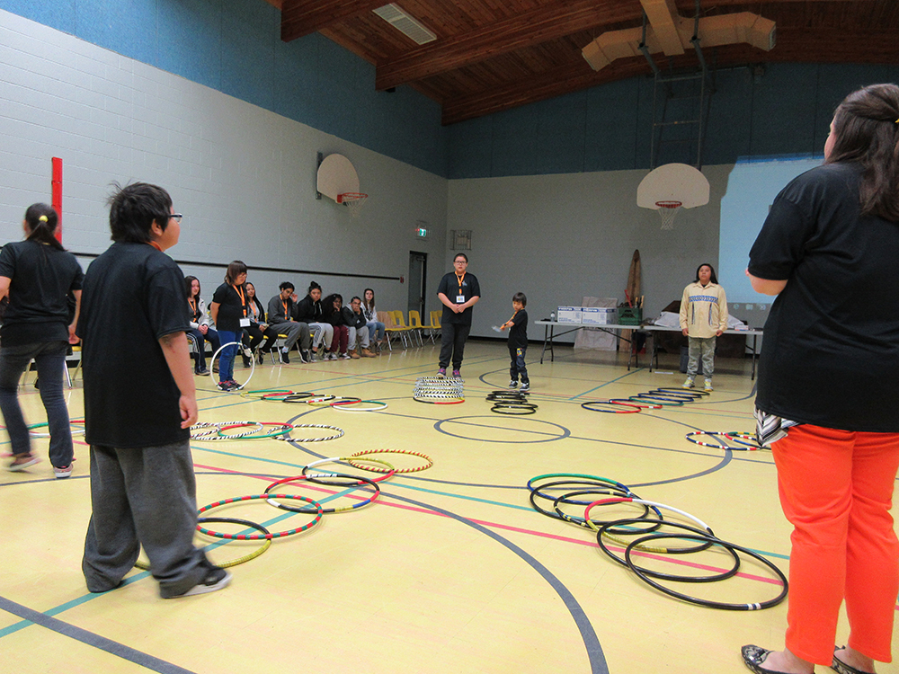 Students doing a hula hoop activity at E-CSLIT general assembly