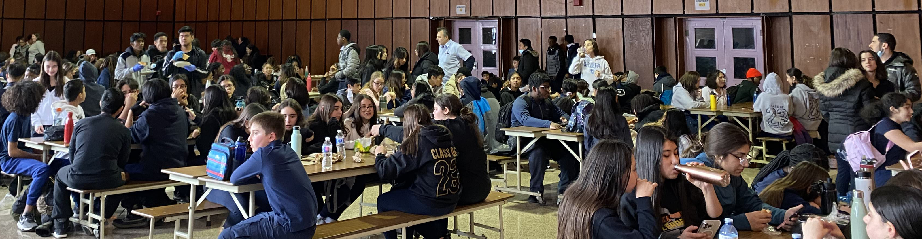 Photo of students attending the i-LITE conference sitting around long tables and eating lunch together.