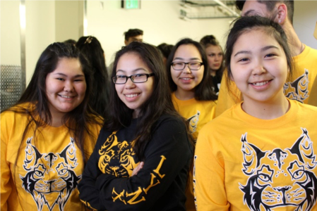 A photo of students wearing a T-shirt with the schools logo.
