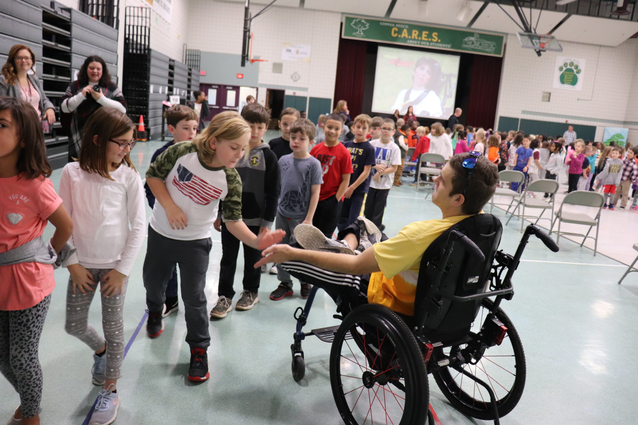 Abled bodied students high-fiving a disabled student