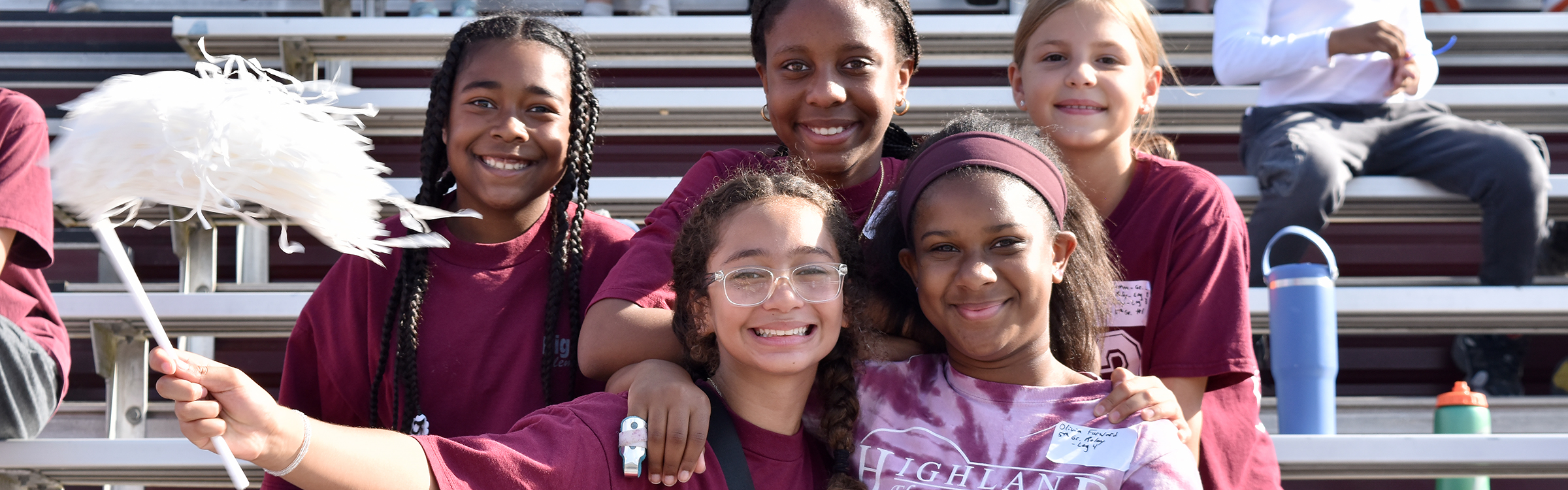 Students sit on the bleachers and cheer for their trammates at the Track &amp; Field Meet