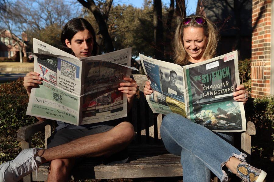 one women and a man reading the newspapaer 