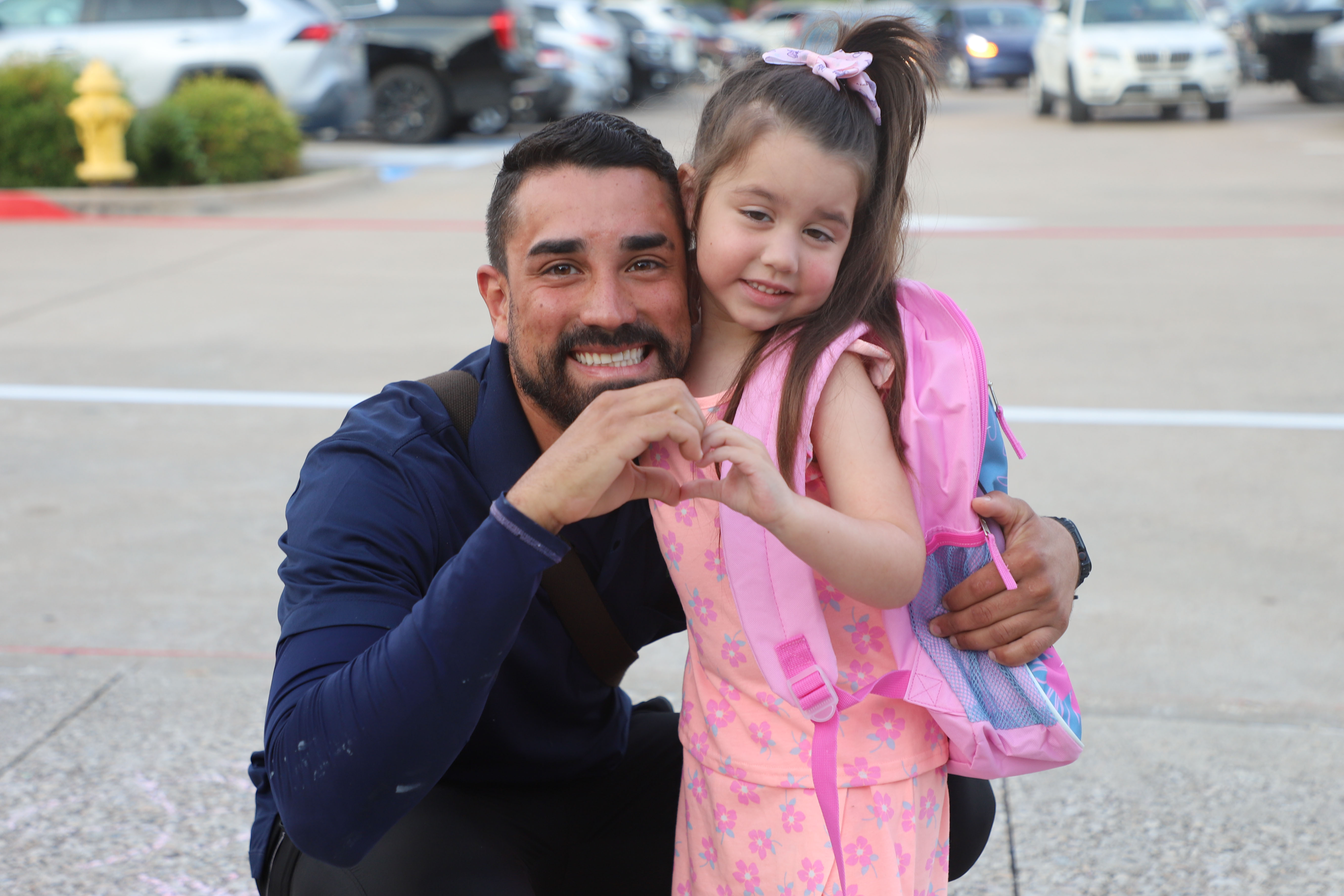 DCE student making a heart with her dad before first day of school