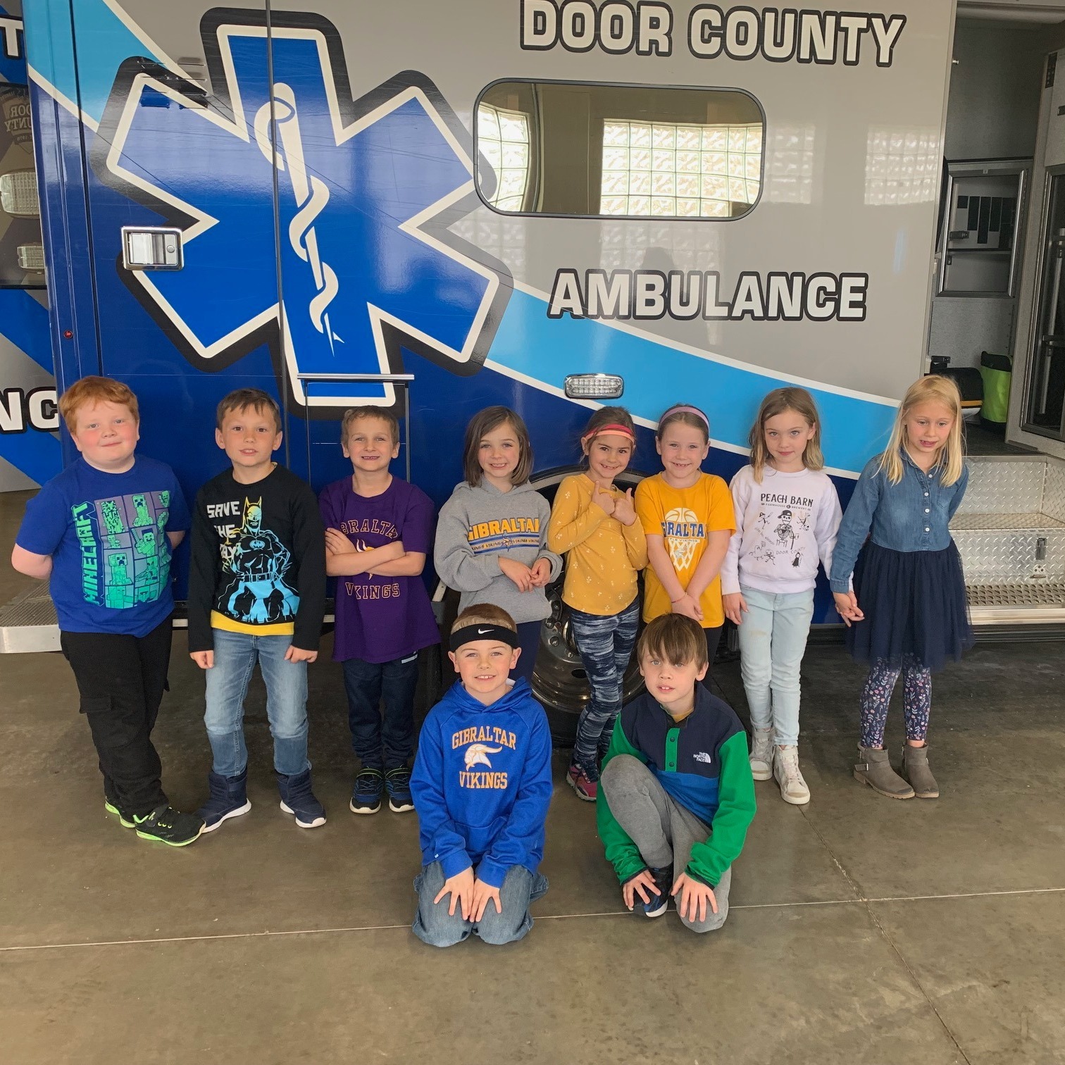 students standing in front of an ambulance