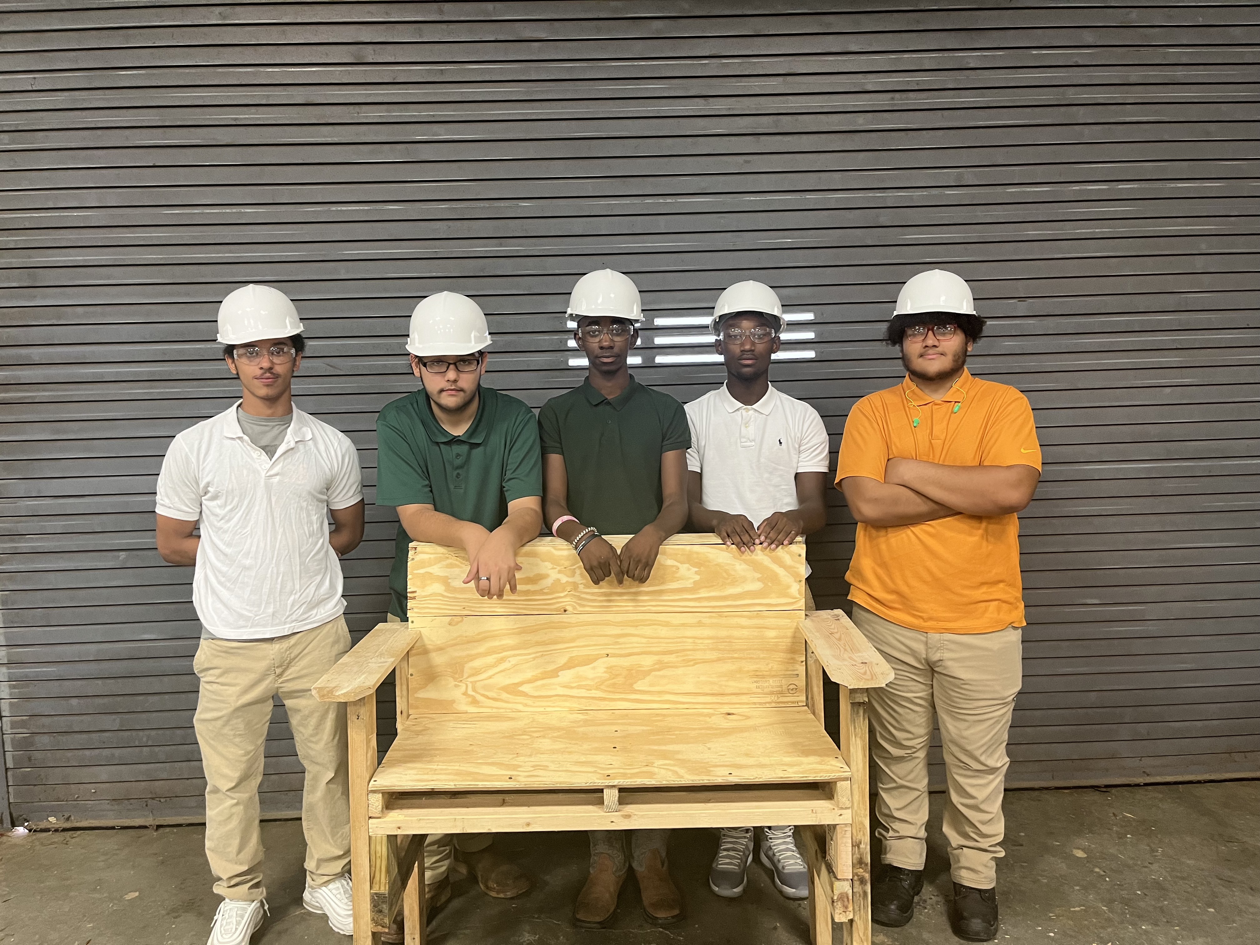 Industrial Maintenance students standing with the bench they made from wood pallets. 