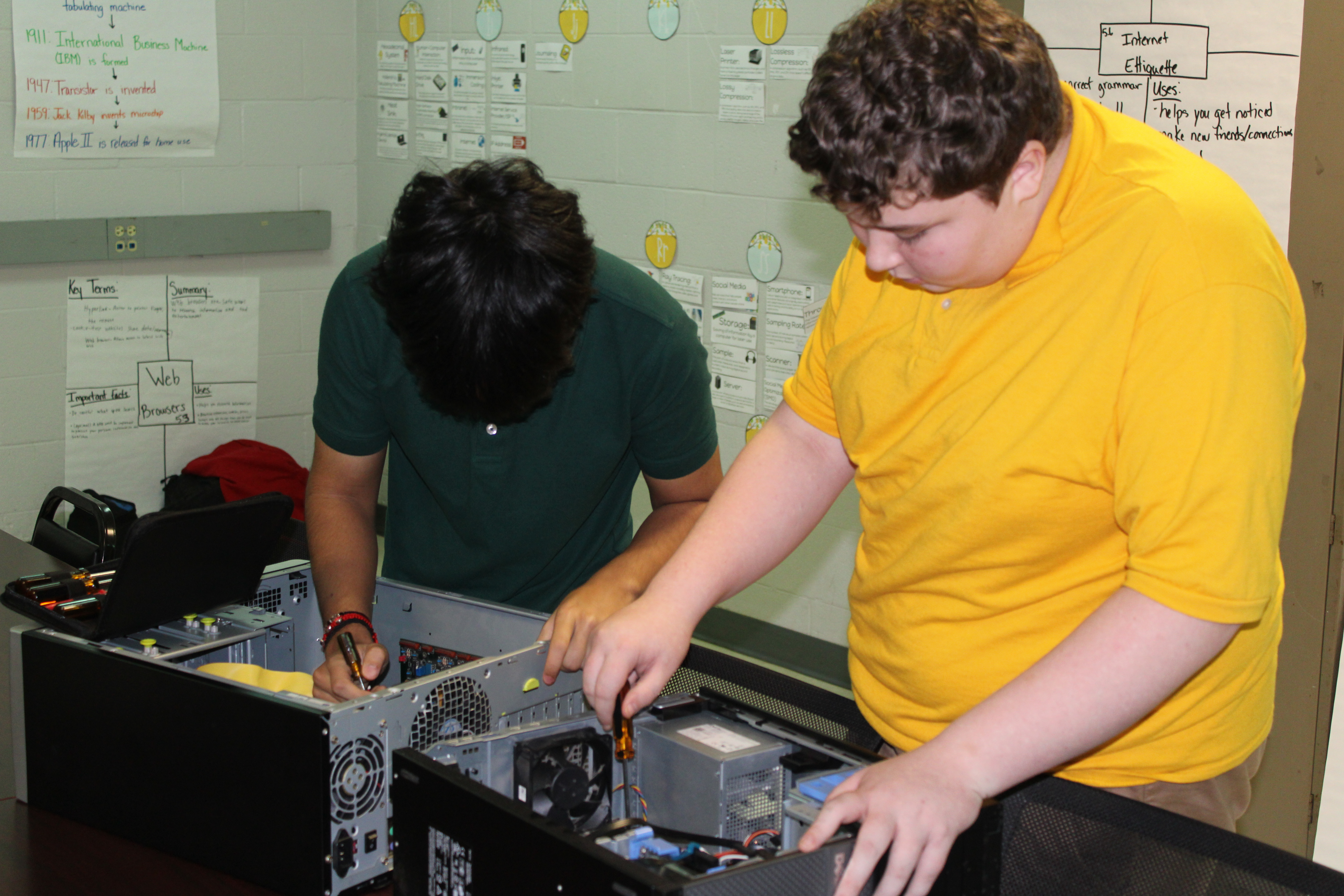 Information Technology students installing a cooling fan.