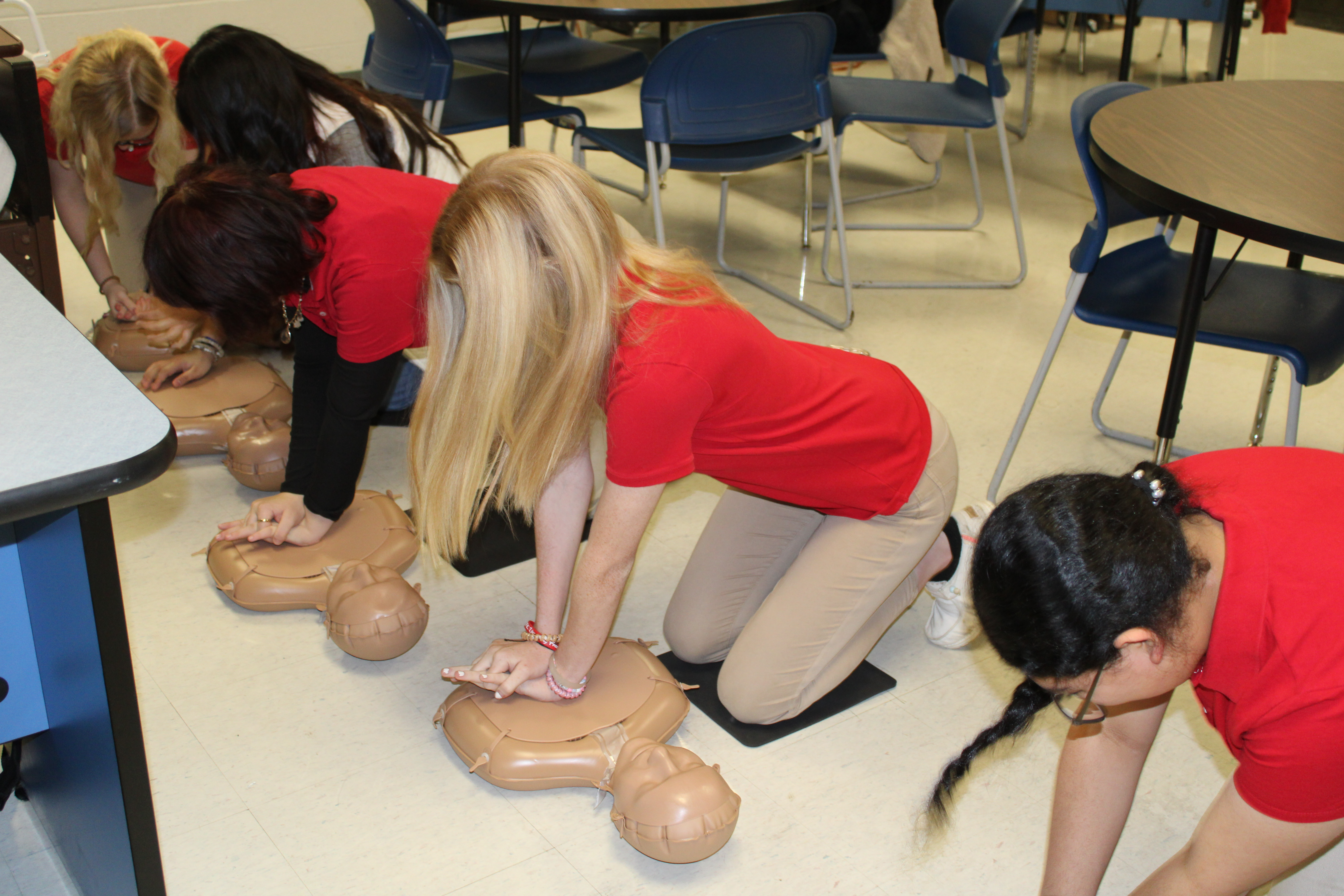 Health Science students practicing CPR on a dummy.