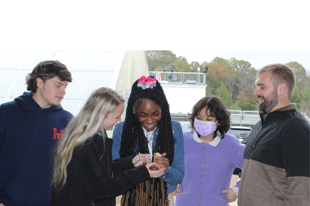 Agriculture students holding a newly hatched chick. 