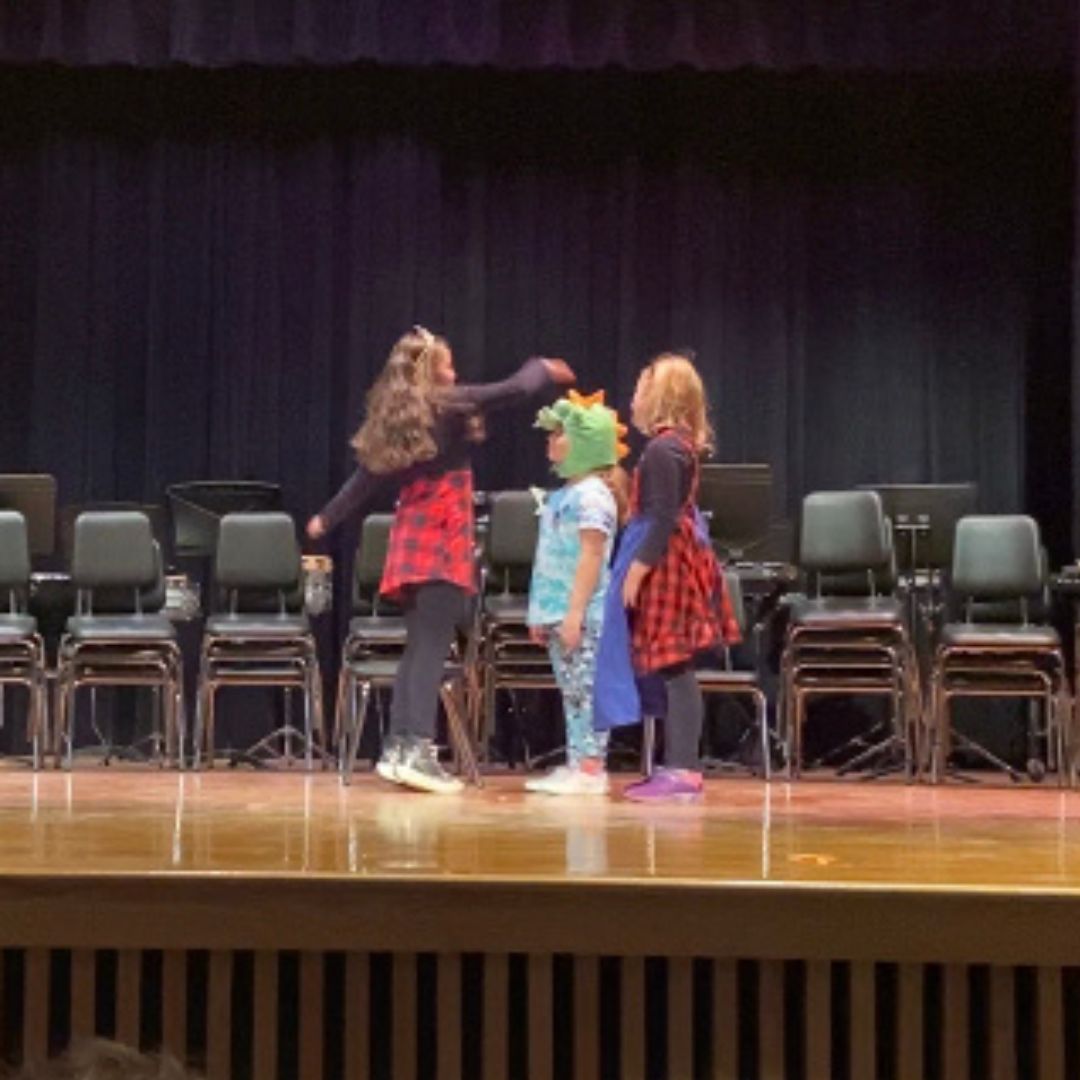 students performing a play on stage