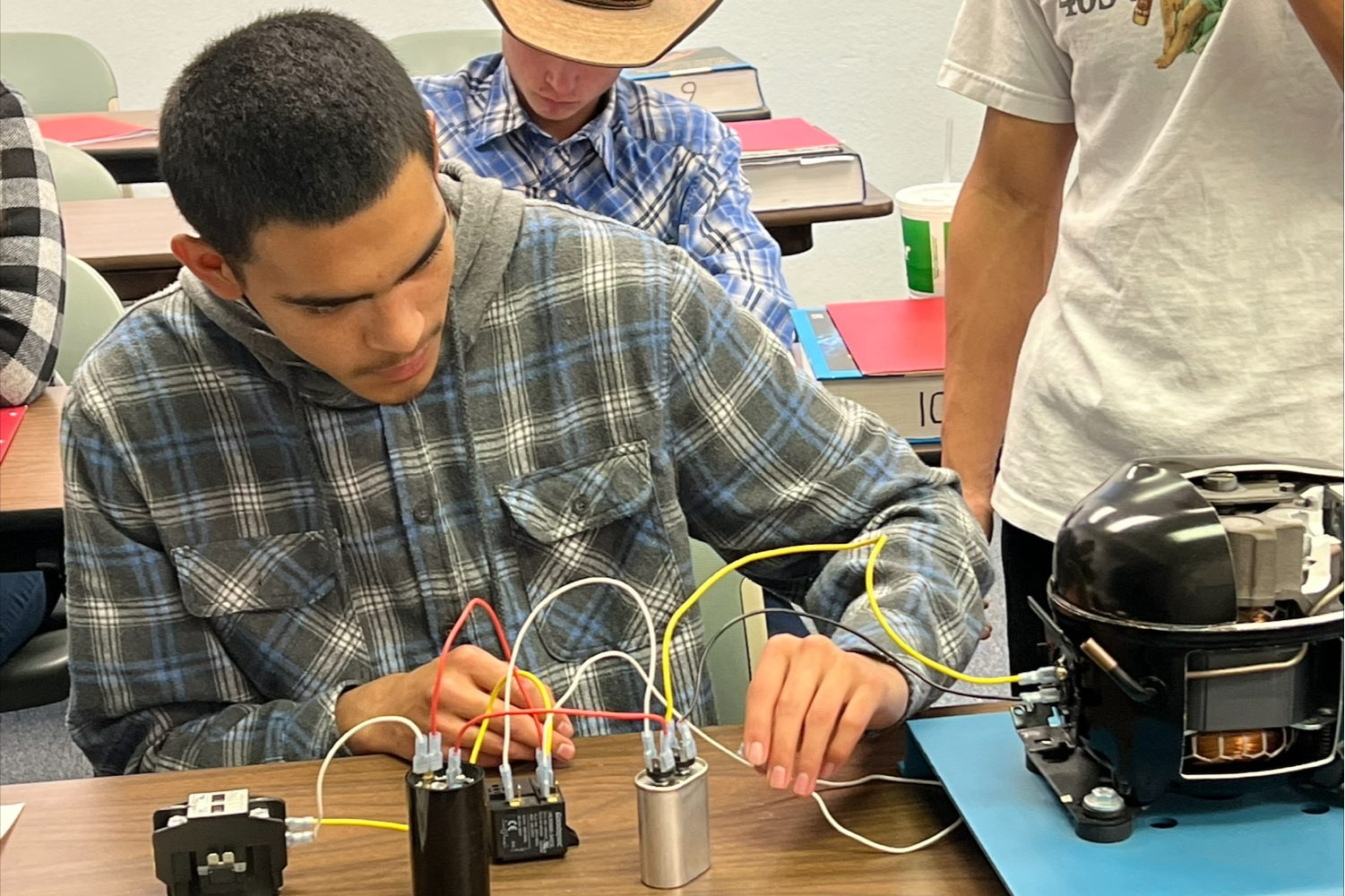 Student practicing wiring on HVAC-R model