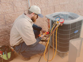a bearded man in a baseball cap working with a series of cables attached to an HVAC unit