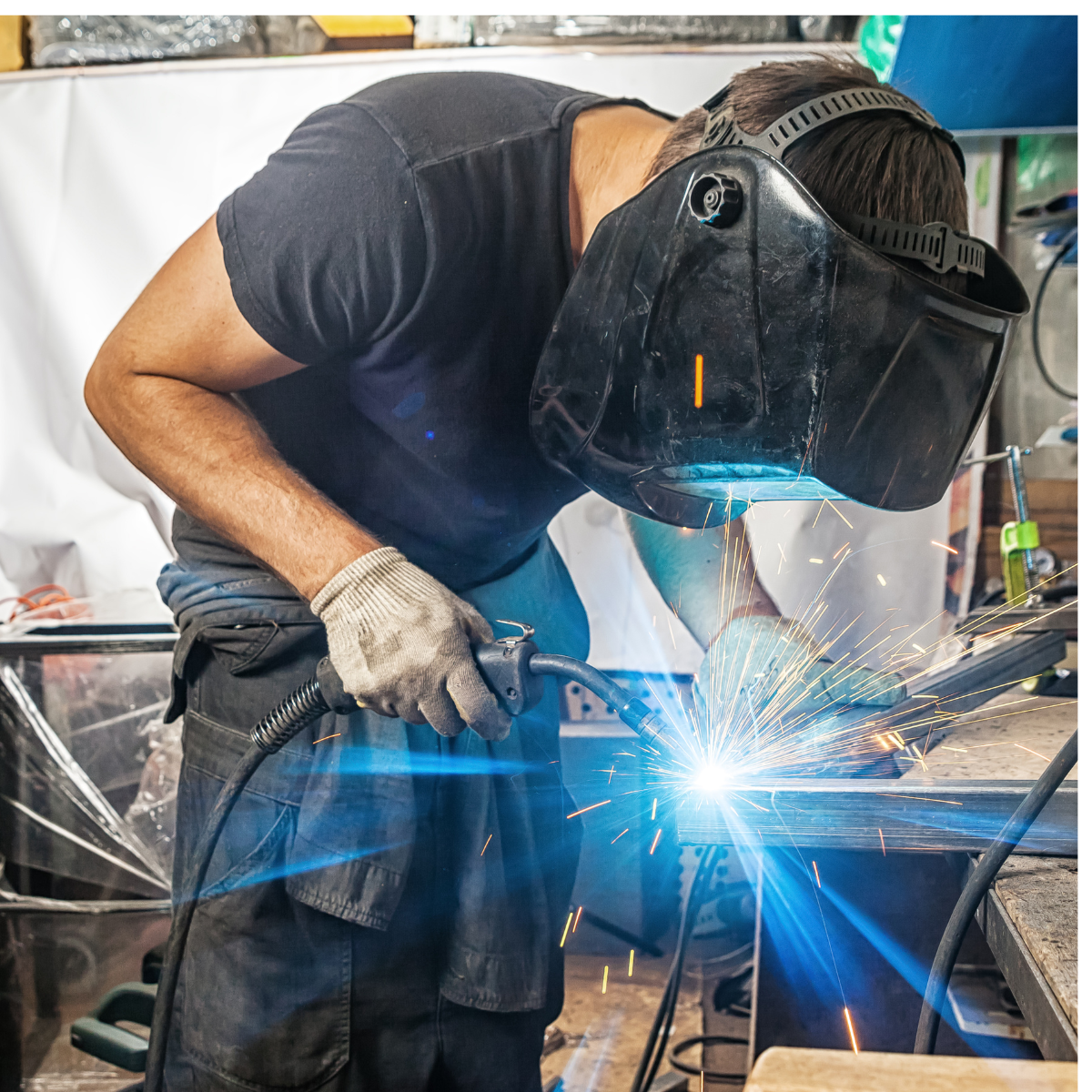 male welder using welding tool with sparks