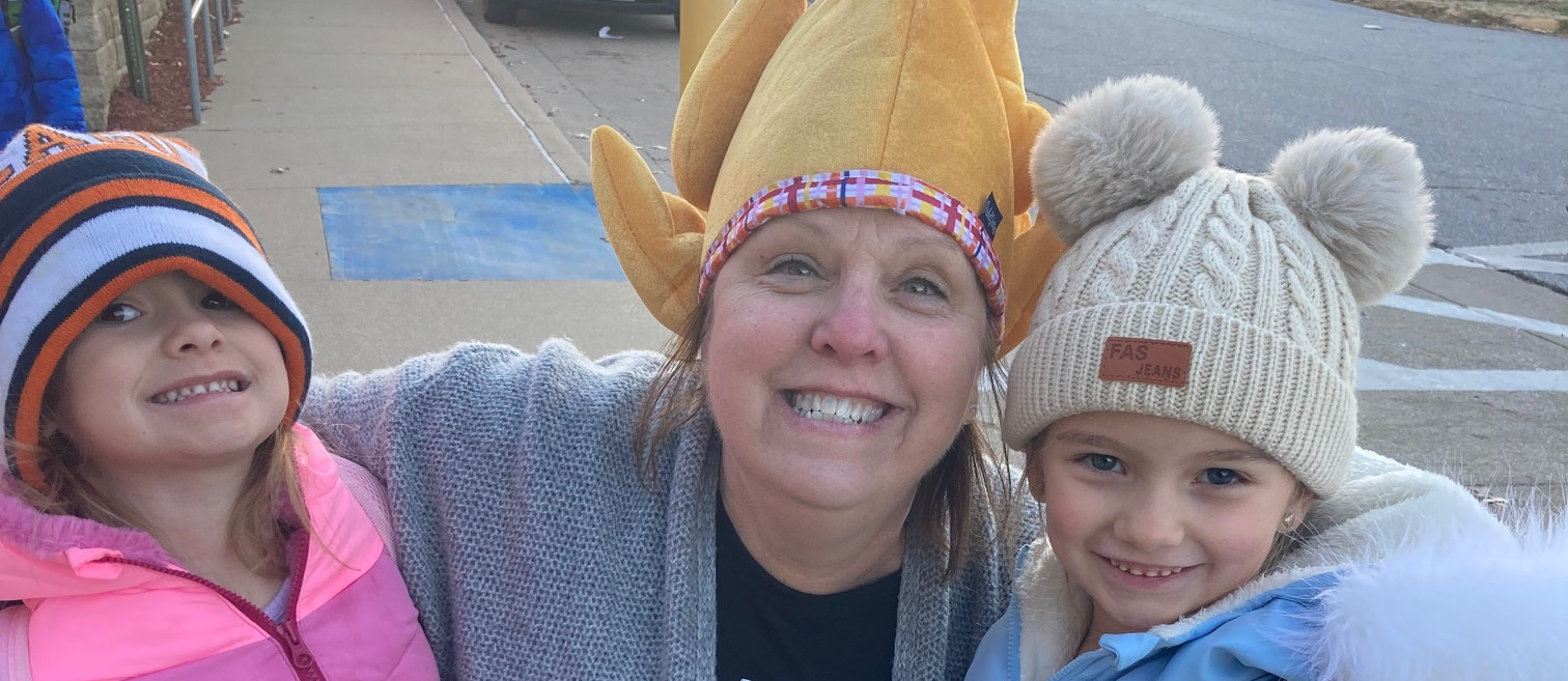 students and teacher wearing turkey and thanksgiving hats on sidewalk